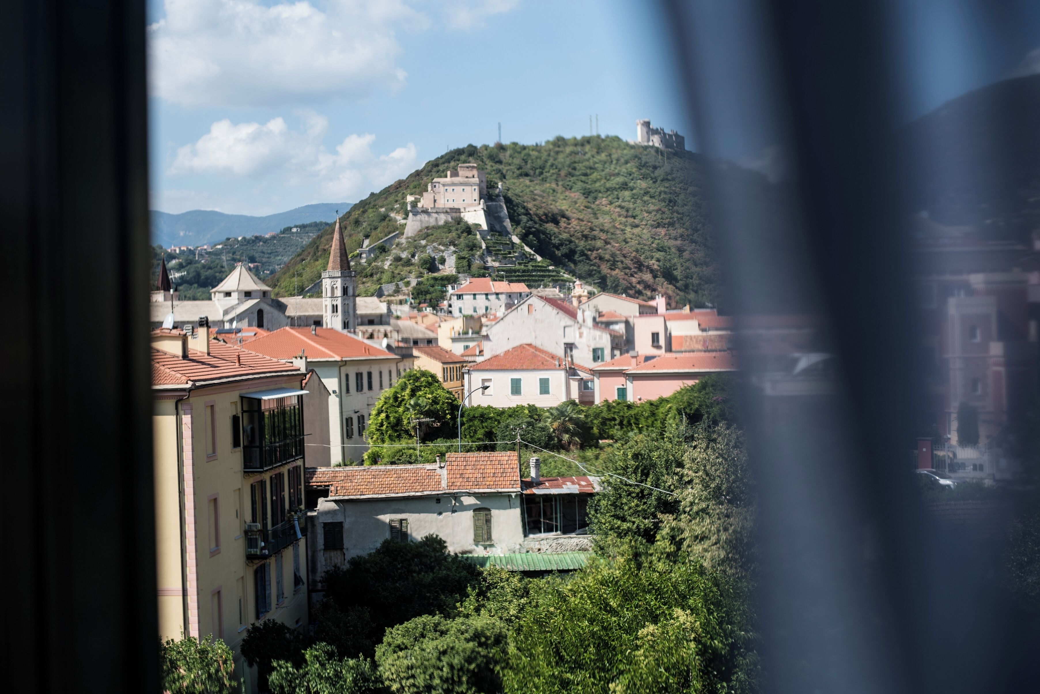 A view of a town with buildings, a hill with a castle, and a church.