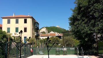 Una piscina con vista su una collina e edifici sullo sfondo.