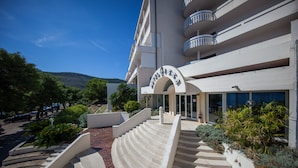 A hotel with a modern design, featuring a prominent arched entrance and a staircase leading to the lobby. - Hotel Issa (Vis)