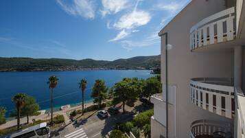 A coastal building with a balcony overlooking a beach and sea.