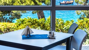 A table with a napkin, salt and pepper shakers, and a blue placemat. - Sagitta all inclusive holiday resort (Omis)