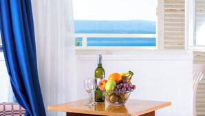 A table with a bowl of fruit, a wine bottle, and a glass. - Sagitta all inclusive holiday resort (Omis)