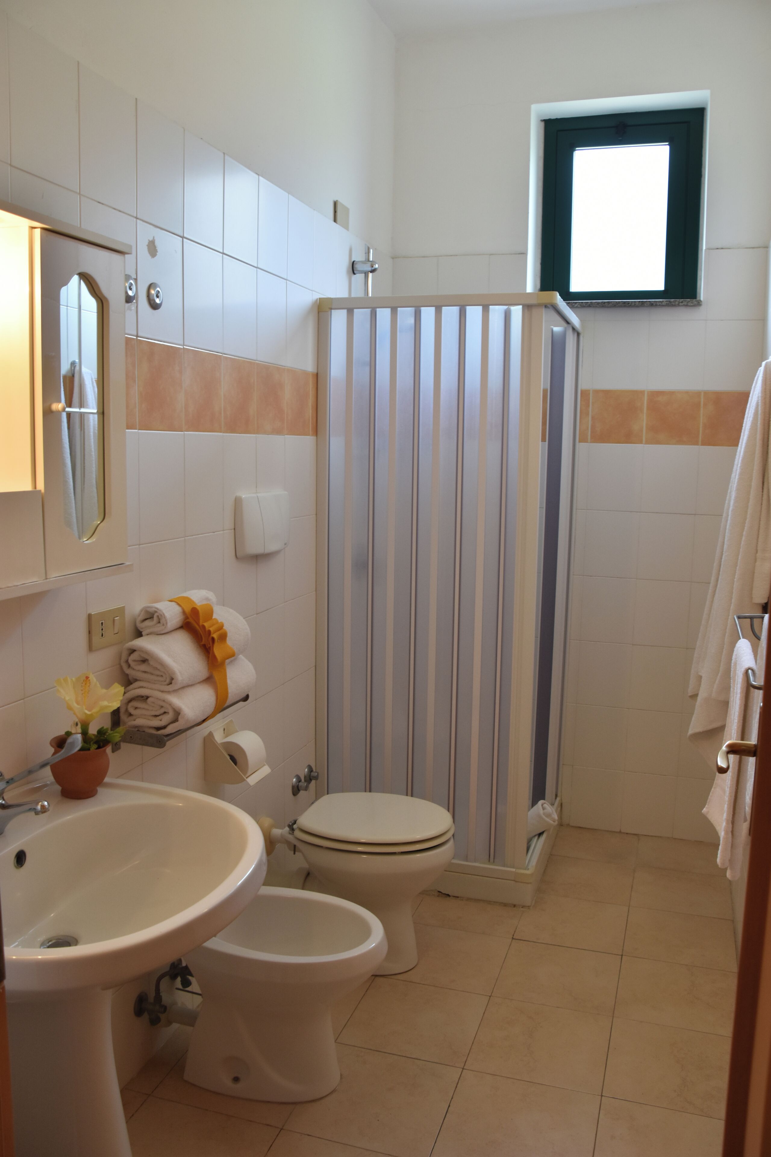 Baño con inodoro, bidé, lavabo y zona de ducha.