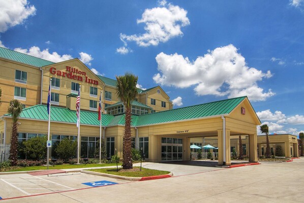 A Hilton Garden Inn with a green roof, a covered entrance, and a parking lot. - Hilton Garden Inn Houston-Pearland (Pearland)
