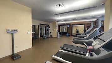 A gym with treadmills, weight machines, and exercise balls.