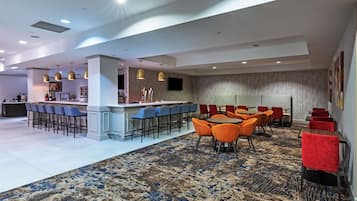 A spacious lobby with a bar area, seating arrangements, and a patterned carpet.