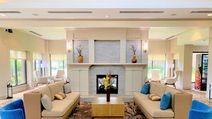A spacious living room with two sofas, a coffee table, and a fireplace. - Hilton Garden Inn Houston/Sugar Land (Sugar Land)