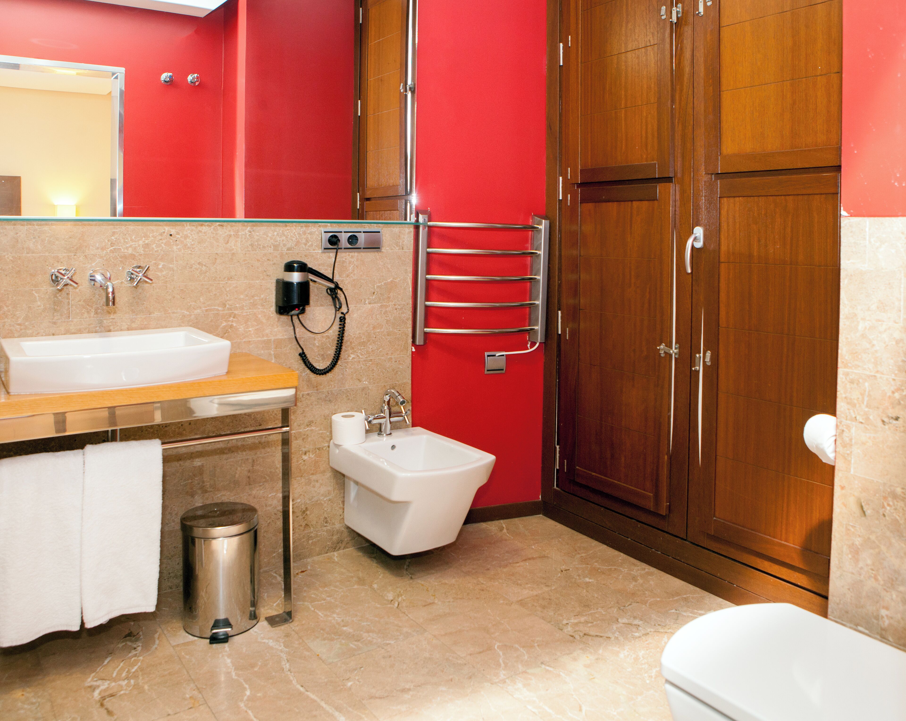 A modern bathroom with a sink, bidet, and toilet.