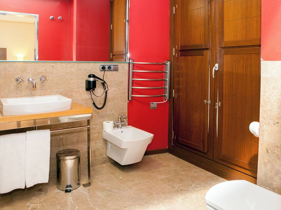 A modern bathroom with a sink, bidet, and toilet.