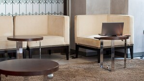 Un hall d’entrée moderne avec un canapé, une petite table, un ordinateur portable et une suspension.