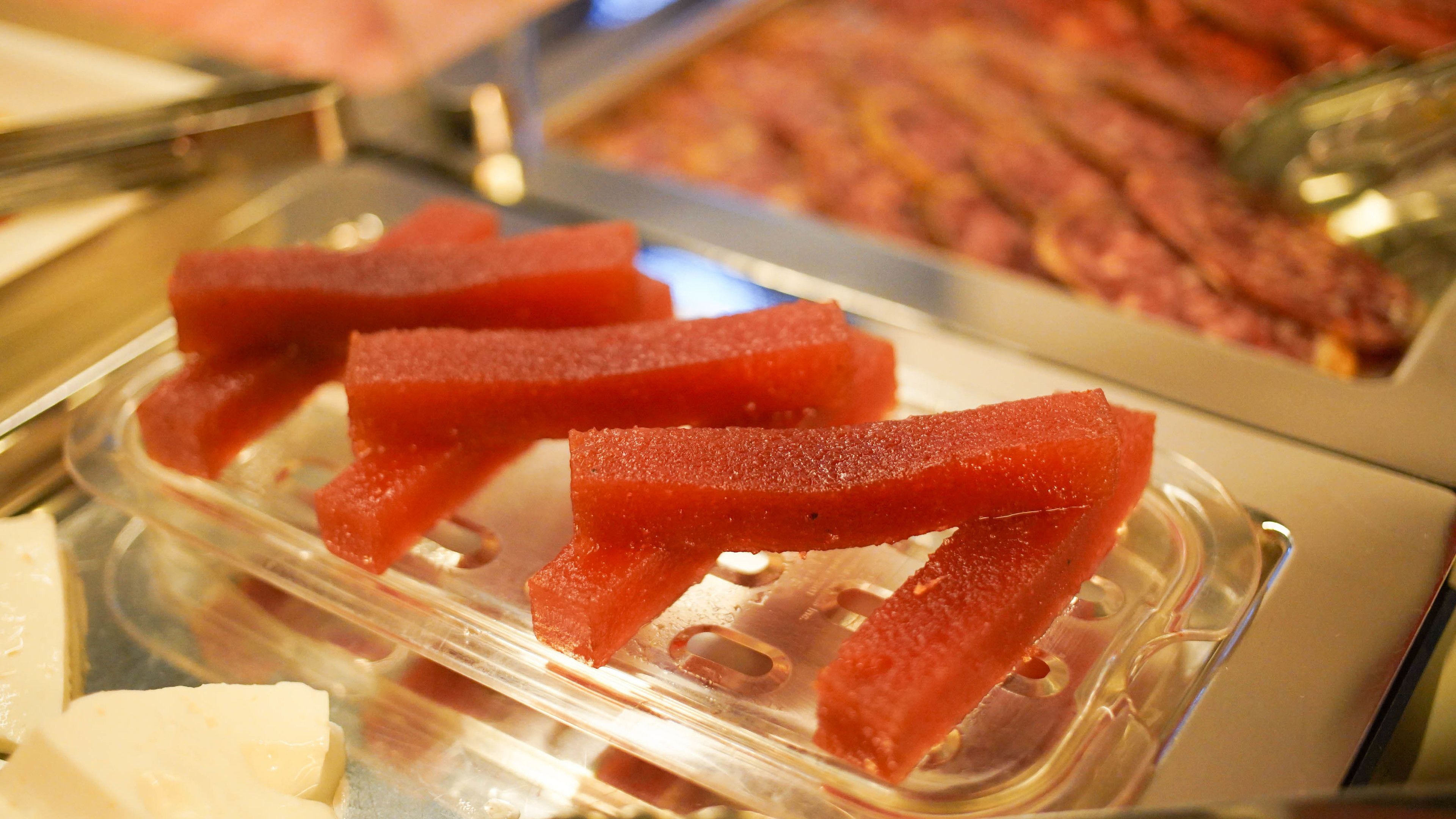 Un bufé con diversos alimentos, incluyendo gelatinas rojas y otros platos.