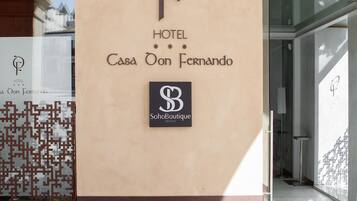 Entrada de un hotel con un logotipo y el nombre 'Casa Don Fernando' bien visibles.