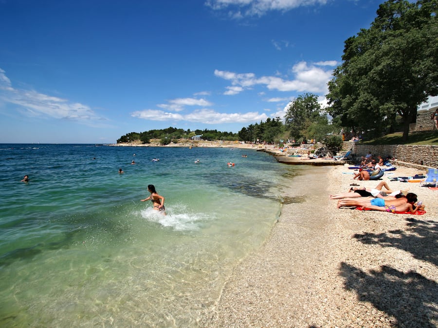 Una playa cerca, sillas reclinables de playa, sombrillas