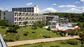 A hotel with multiple balconies, a swimming pool, and lush greenery. - Hotel Istra Plava Laguna (Porec)
