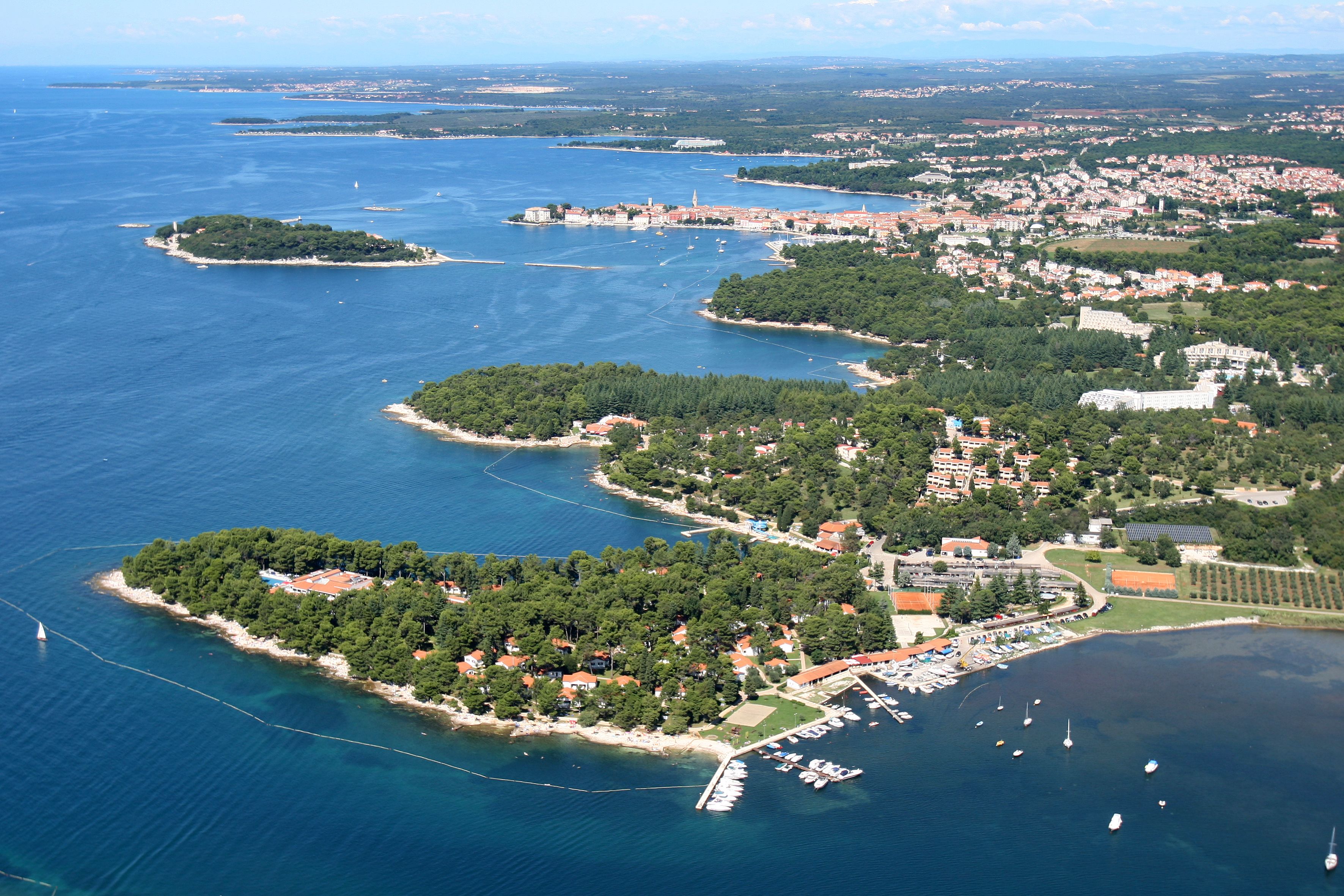 An aerial view of a coastal town with multiple islands, a marina, and residential areas.