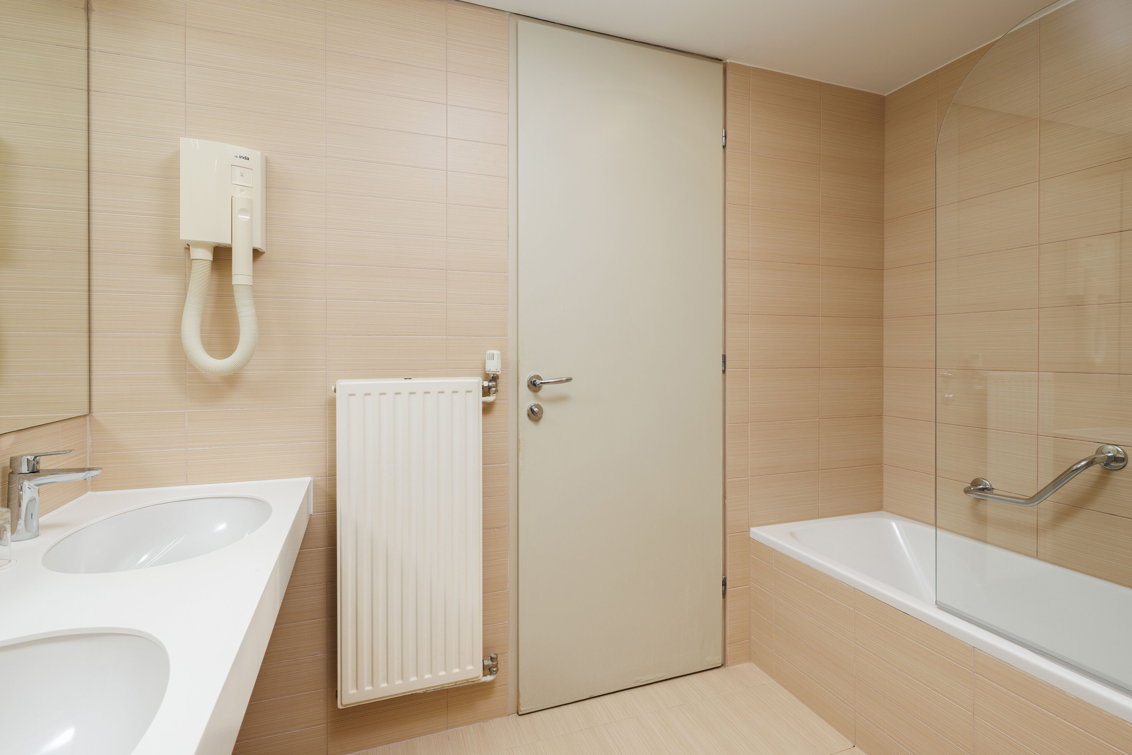 A bathroom with two sinks, a toilet, a shower, and a bathtub.