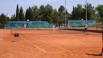 Ein Lehm-Tennisplatz mit Werbung für Yonex und Büchel.