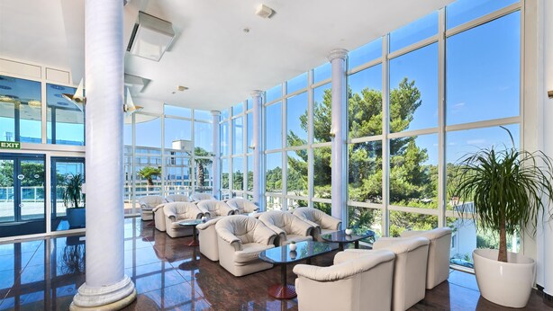 A spacious lobby with large windows, a polished floor, and a seating area with sofas and a coffee table. - Hotel Gran Vista Plava Laguna (Porec)