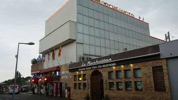 A hotel with a modern facade, a visible reception area, and a sign indicating it is a location for receptions.