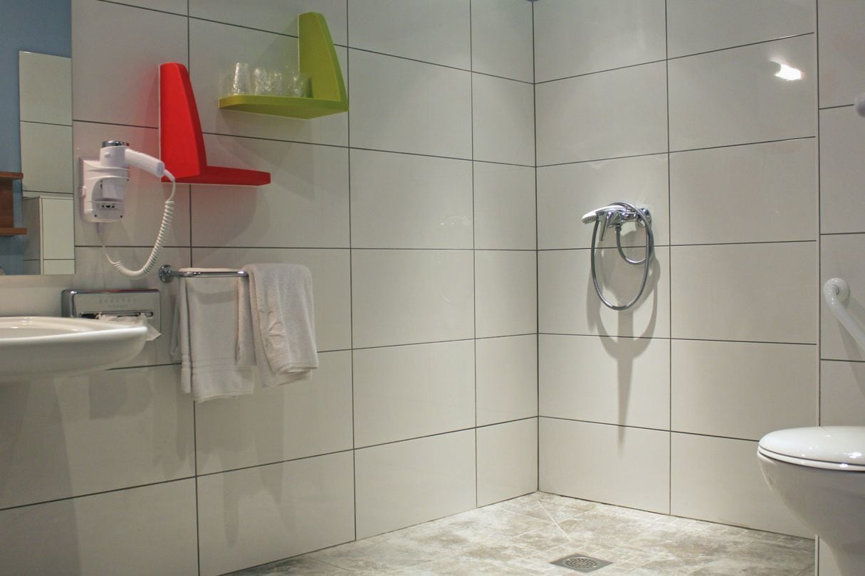 Une salle de bain équipée d’une douche, de toilettes, d’un lavabo et d’un porte-serviettes.