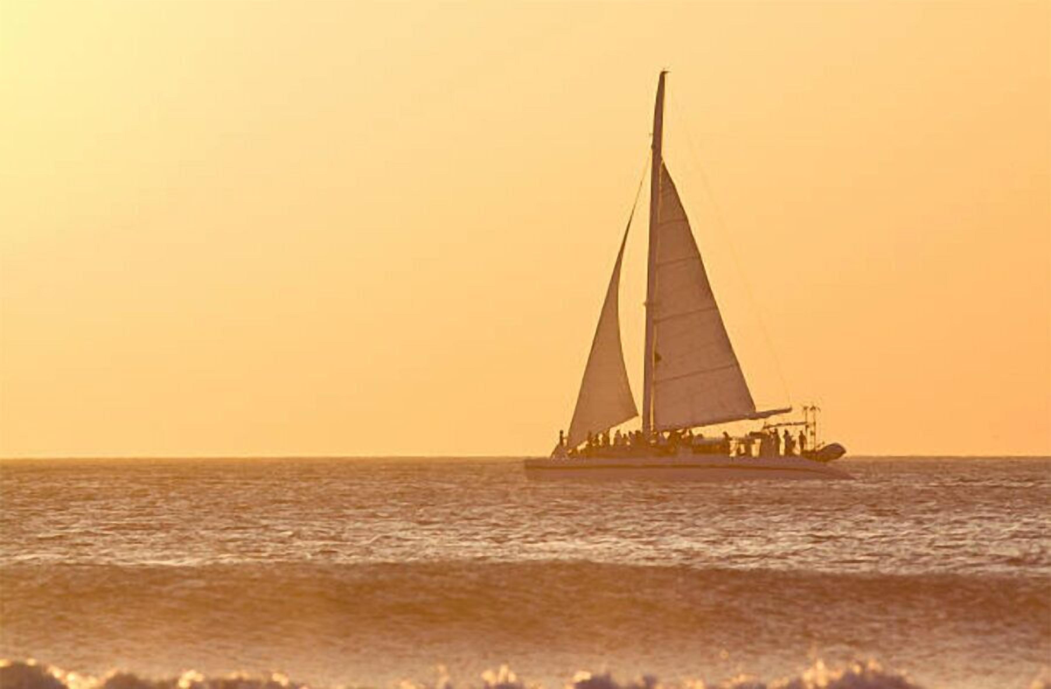 A sailboat on the water during sunset.