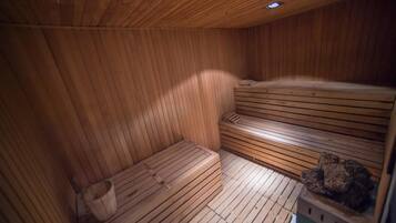 Uma sauna de madeira com bancos e uma bacia de pedra.