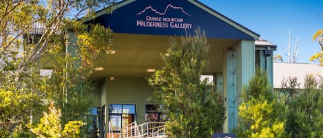 A building with a sign reading "Cradle Mountain Wilderness Gallery" and a staircase leading to the entrance.