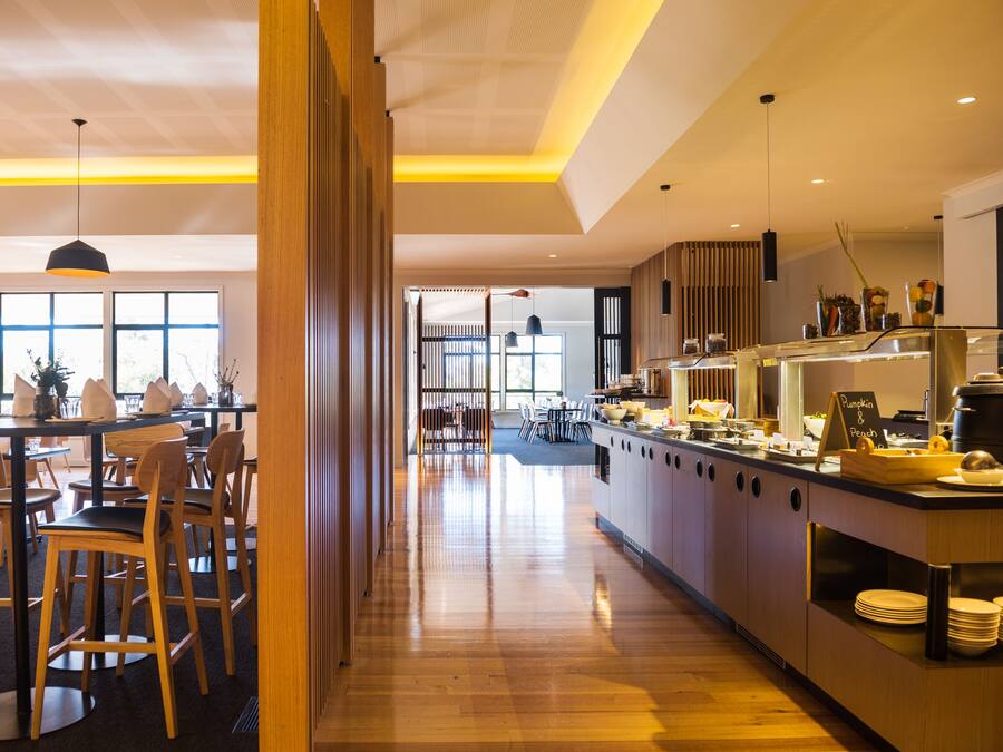 Un restaurante moderno con mobiliario de madera y una barra larga.
