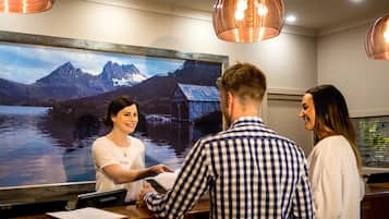 A reception desk with a large framed picture of a mountain landscape.