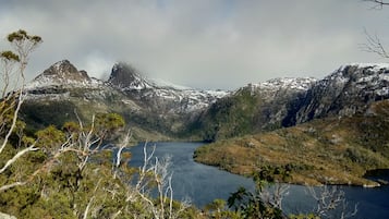 Un paisaje montañoso con un lago y picos nevados.