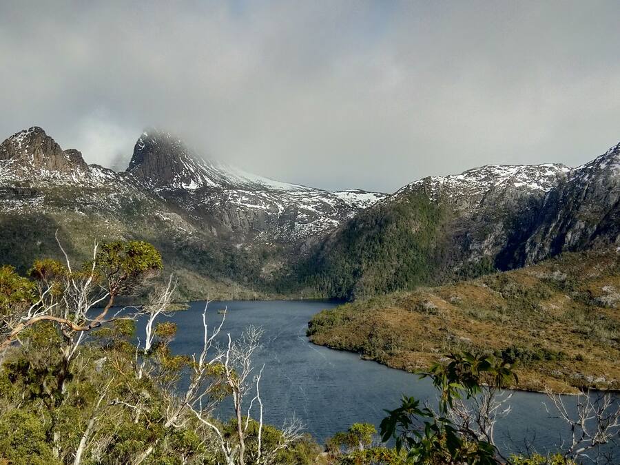 Un paisaje montañoso con un lago y picos nevados.