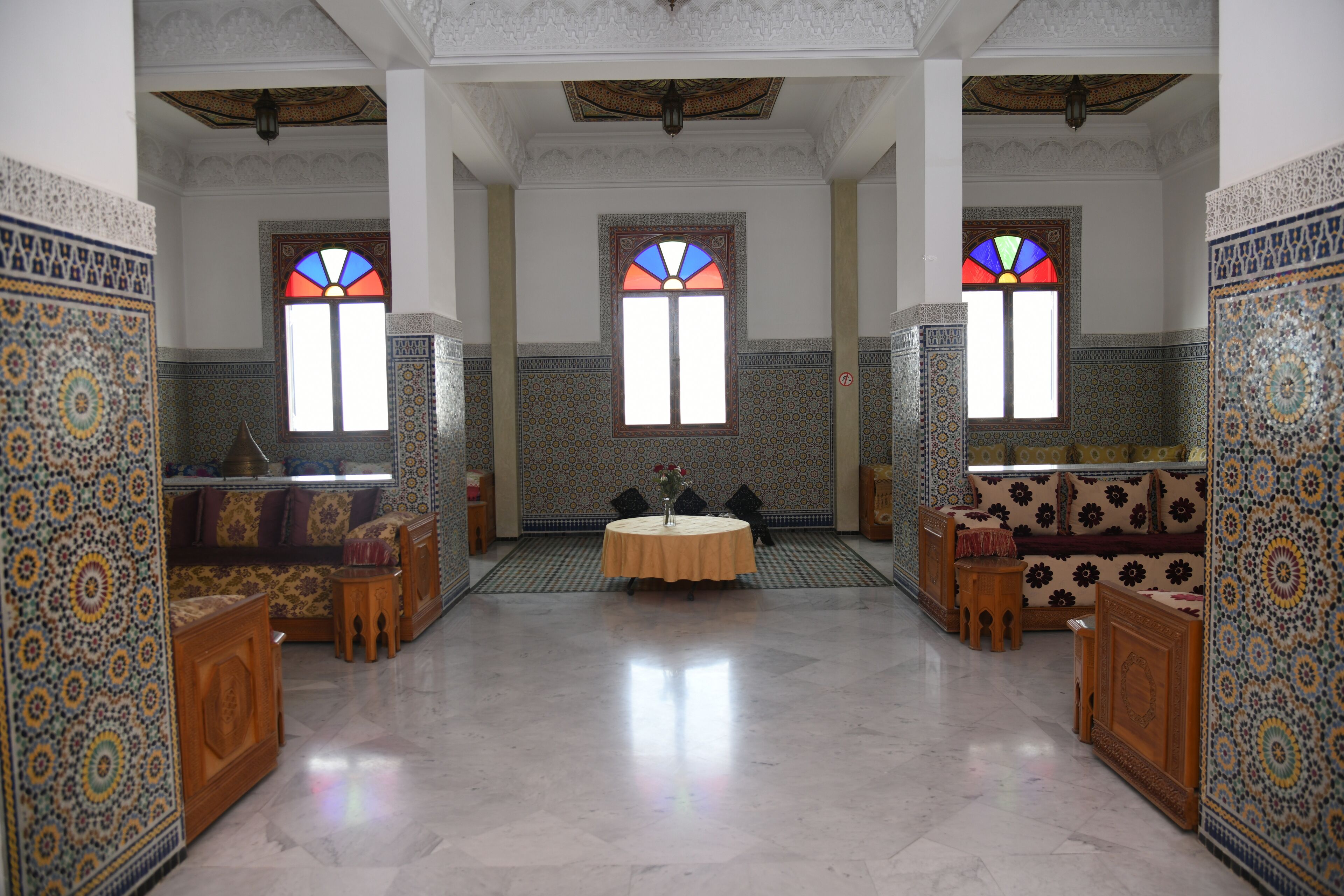A spacious room with patterned walls, a round table, and two sofas.