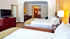 A hotel room with two beds, a TV, a desk, and a bathroom visible through an archway. - Holiday Inn Express Hotel & Suites Brooksville by IHG (Brooksville)