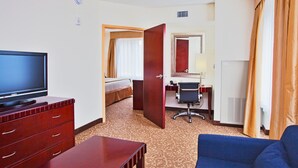 A hotel room with a television, a desk, a chair, a sofa, and a bed. - Holiday Inn Express Hotel & Suites Brooksville by IHG (Brooksville)