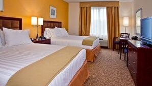 A hotel room with two beds, a desk, a chair, a television, and a window with curtains. - Holiday Inn Express Hotel & Suites Brooksville by IHG (Brooksville)