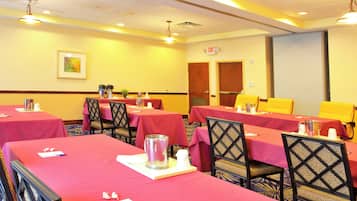 A conference room with tables set for meetings, equipped with nameplates, pens, and water pitchers.