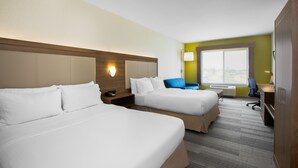 A hotel room with two beds, a desk, and a chair.