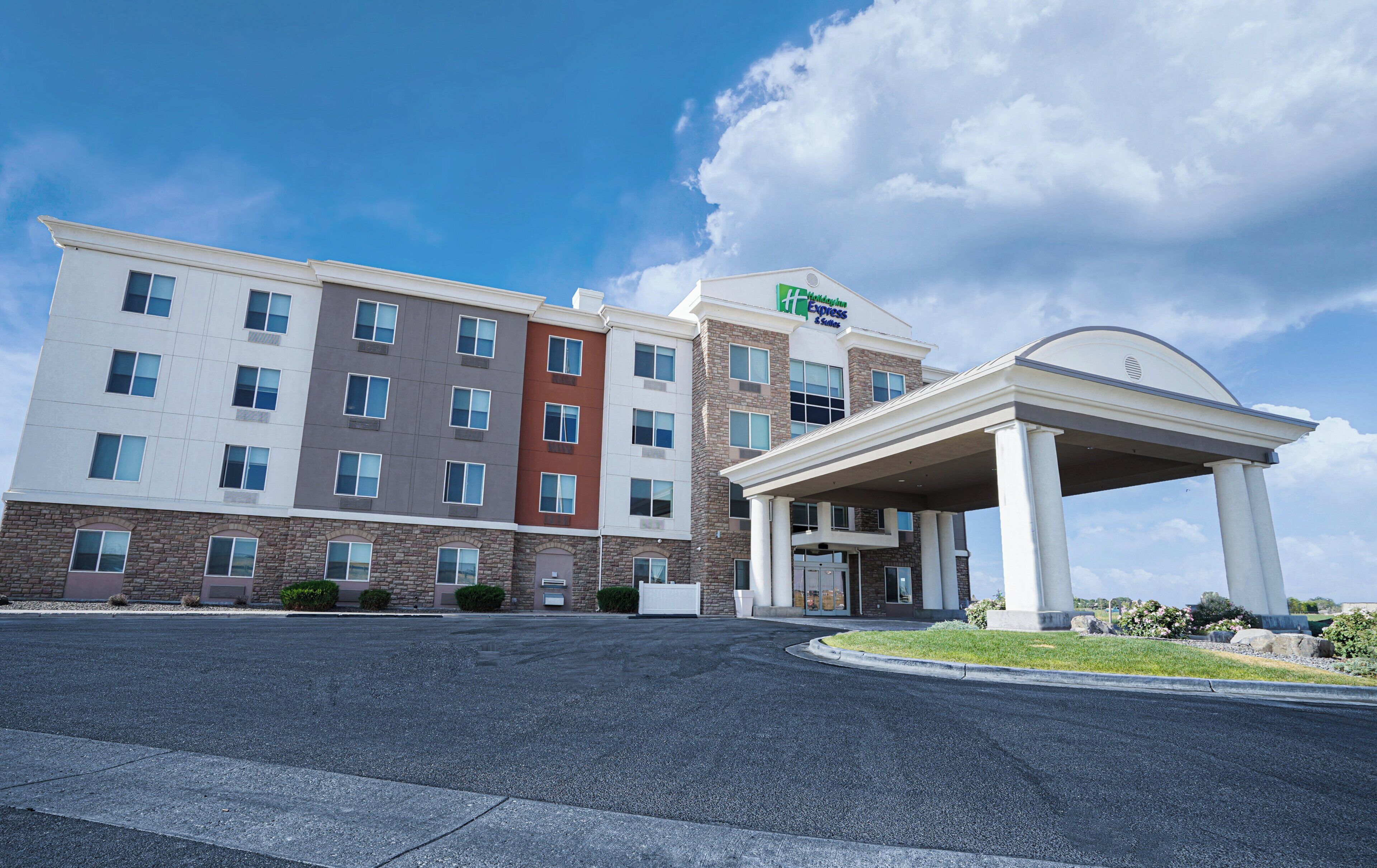 A multi-story hotel with a central entrance and a covered waiting area.