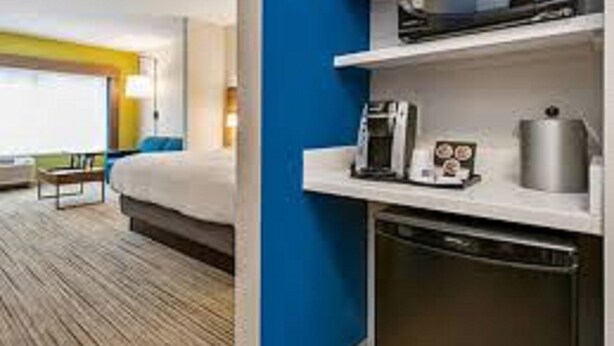 Une chambre d’hôtel équipée d’un lit, d’une machine à café, d’un four à micro-ondes et d’un lave-vaisselle.