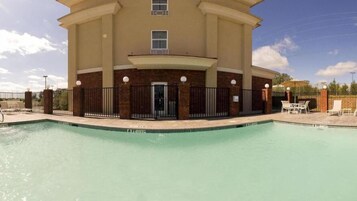 Una piscina con un edificio al fondo.