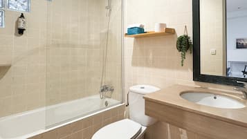 Une salle de bain avec une baignoire, des toilettes et un lavabo.