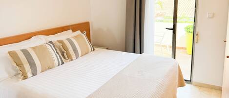 Ein Hotelzimmer mit Bett, Blick ins Freie und Zugang zum Balkon.
