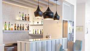 A modern kitchen with a bar area, stainless steel appliances, and a bar stool seating arrangement. - Park Hotel Porto Gaia (Vila Nova de Gaia)