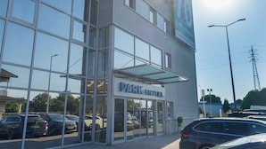 A modern building with a glass facade, a sign reading 'PARK HOTEL,' and parked cars in front. - Park Hotel Porto Gaia (Vila Nova de Gaia)