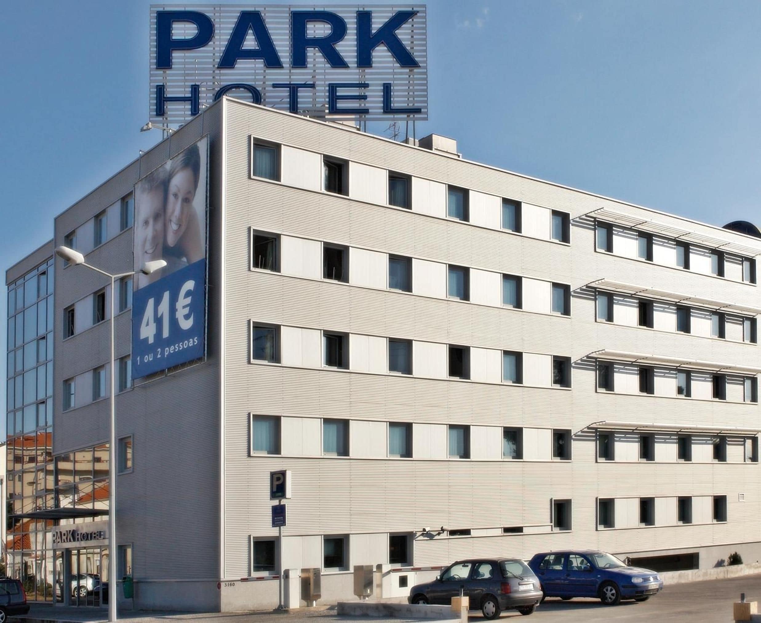 A multi-story hotel building with a prominent sign for the PARK HOTEL.