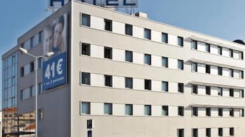 Un edificio de hotel de varios pisos con un cartel llamativo que dice PARK HOTEL.