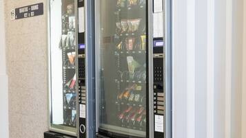 Deux distributeurs automatiques sont installés dans un couloir, et une pancarte indique : « Chambres 822 à 831 ».