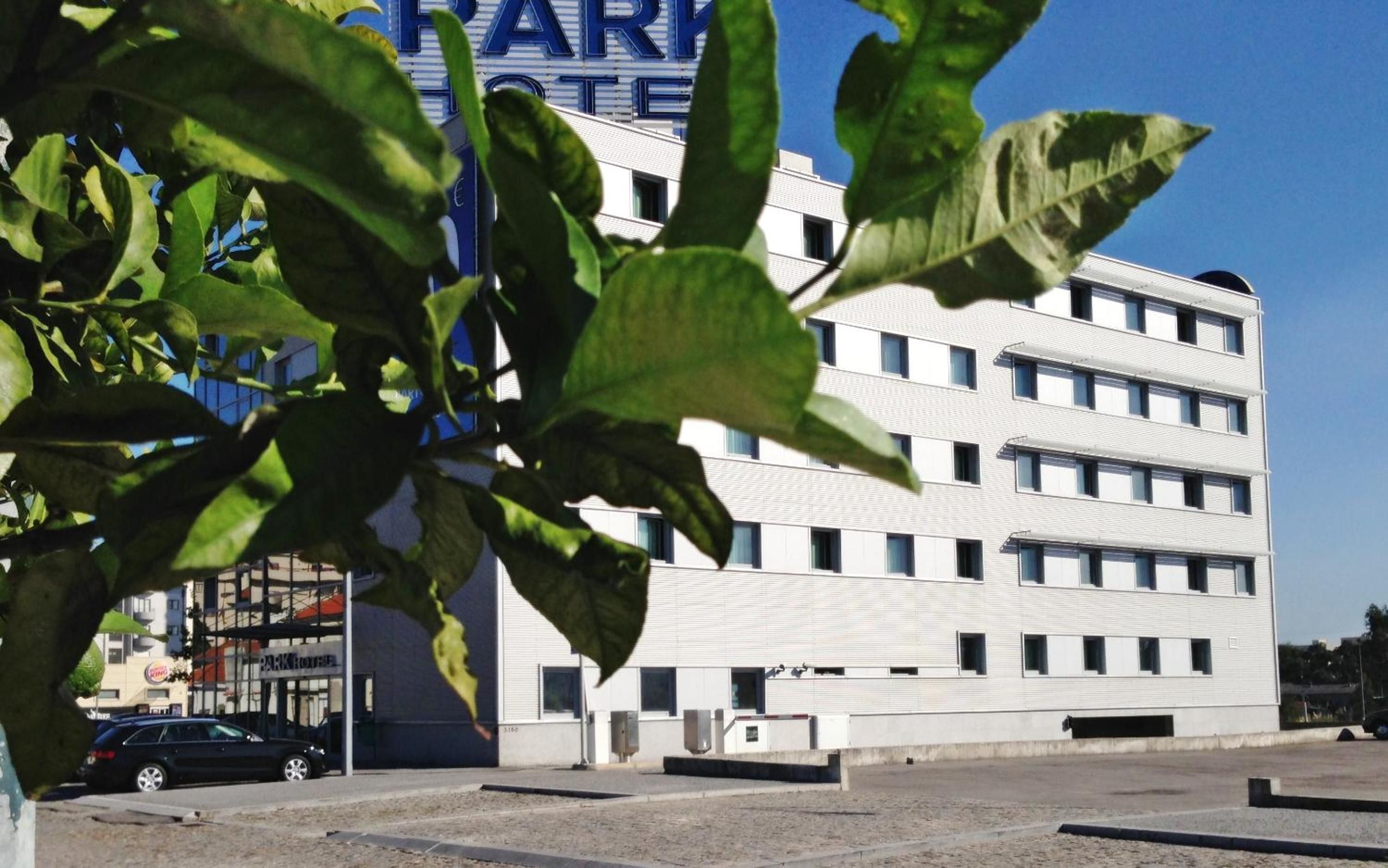 A multi-story building with a parking lot in front.