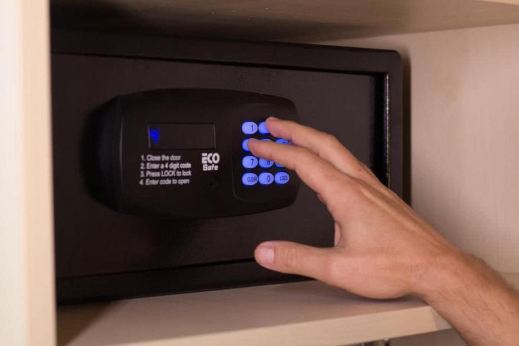 Una mano interactuando con un teclado de combinación digital en una puerta.