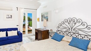 A bedroom with a bed, a blue sofa, a nightstand, and a decorative headboard.